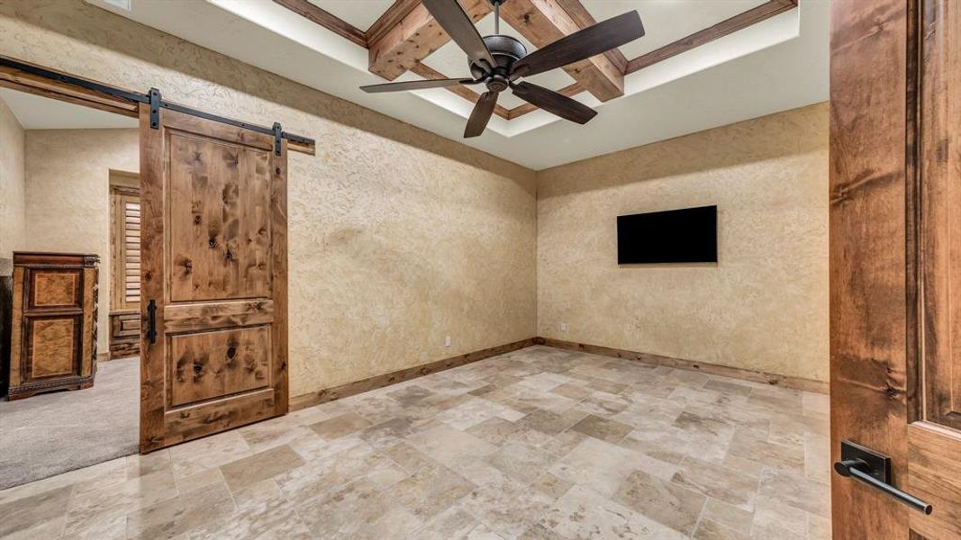 Versatile space with tray ceiling and wood beam accents, perfect for a media room, workout area, or guest suite.