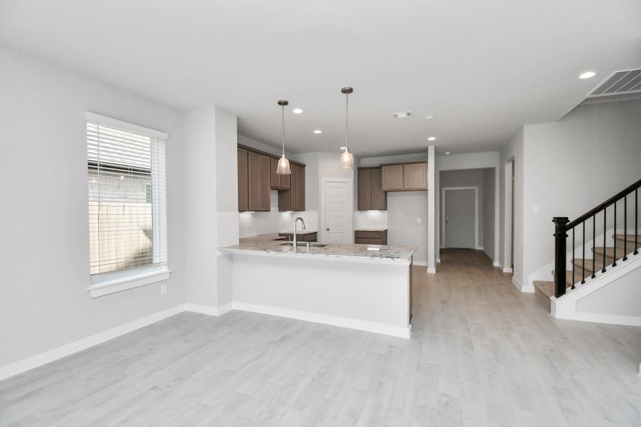 Discover another perspective of this stunning kitchen, generously appointed with an abundance of counter space. Sample photo of completed home with similar floor plan. Actual colors and selections may vary.
