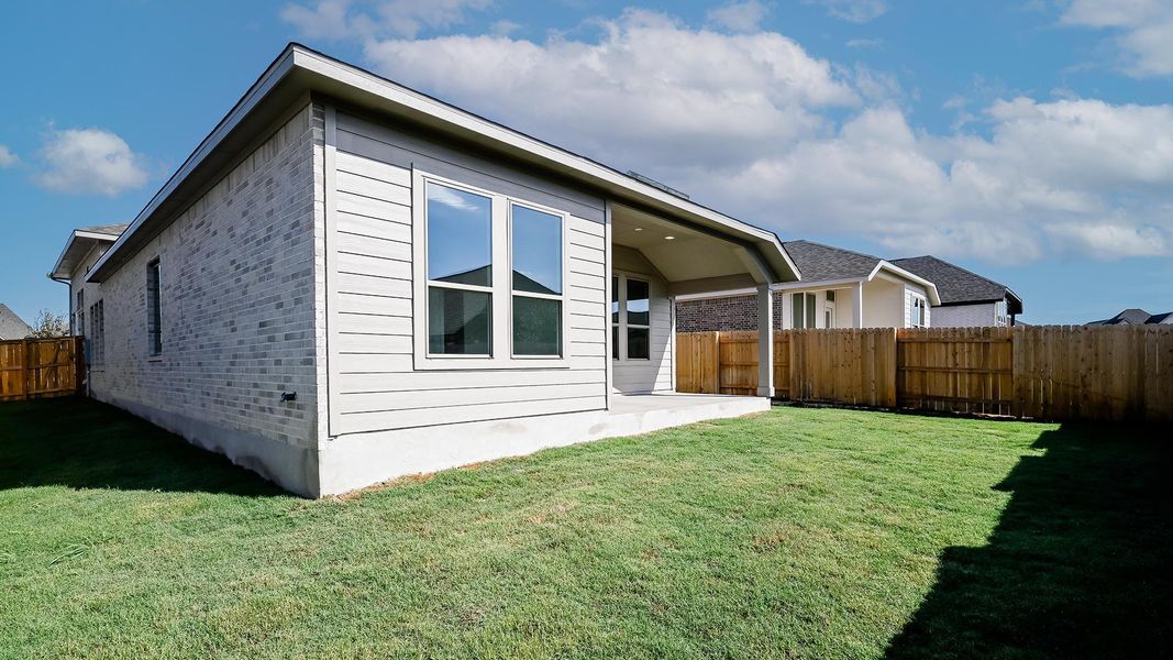 Back of house with a fenced backyard, a patio area, and brick siding
