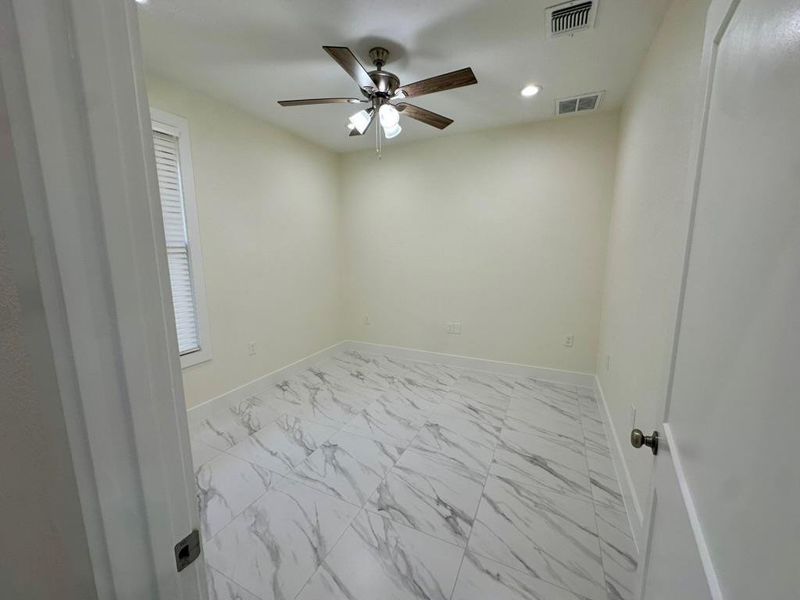 Empty room with recessed lighting, light marble finish floors, and ceiling fan