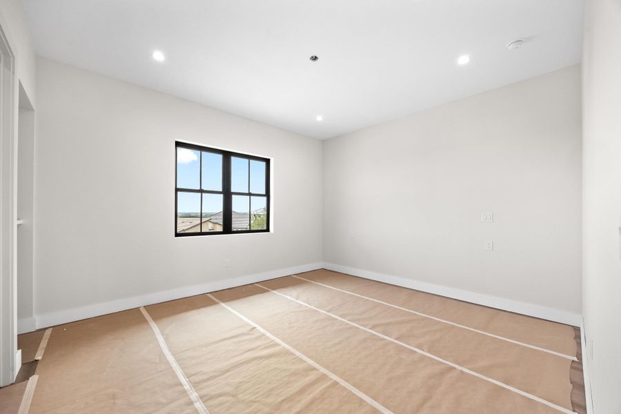 Room featuring white walls, recessed lighting, and a black-framed window