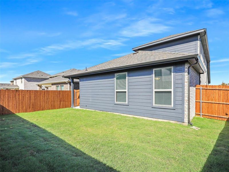 Rear view of house with a yard and a fenced backyard Rear view of house with a yard and a fenced backyard