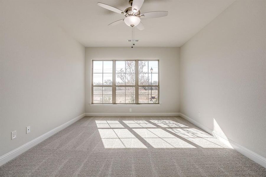 Spare room with a ceiling fan and light carpet