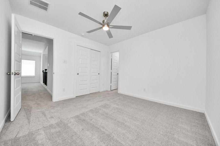 Generously sized secondary bedrooms featuring spacious closets, soft and inviting carpeting underfoot, large windows allowing plenty of natural light, and the added touch of privacy blinds for your personal retreat. Sample photo of completed home with similar floor plan. Actual colors and selections may vary.