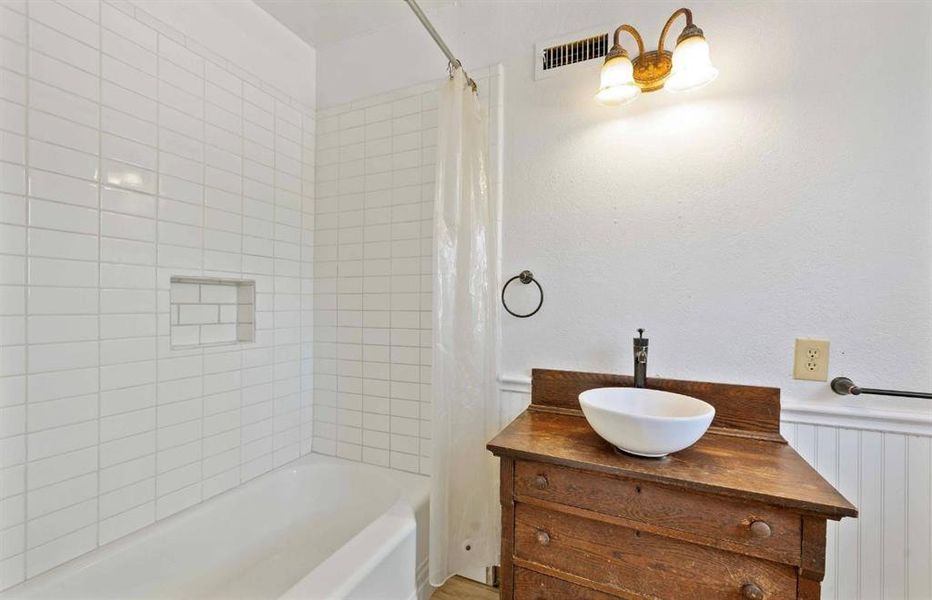 Full bath featuring shower / bath combo and vanity