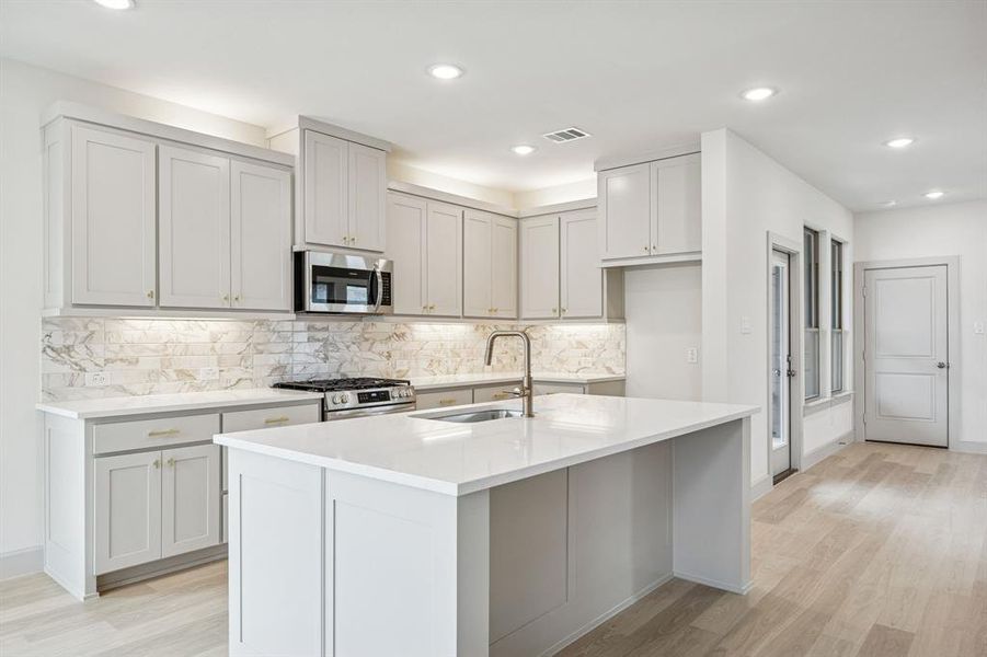 This dream home features a spacious kitchen island where friends and family are sure to gather round!