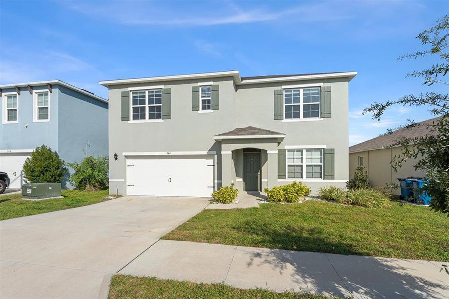 Front exterior of a new home in Grace Ranch, Haines City, FL, highlighting curb appeal (Image 21). Front exterior of a new home in Grace Ranch, Haines City, FL, highlighting curb appeal (Image 21).