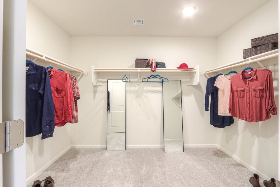 A room with a closet and clothes on the wall. A room with a closet and clothes on the wall.