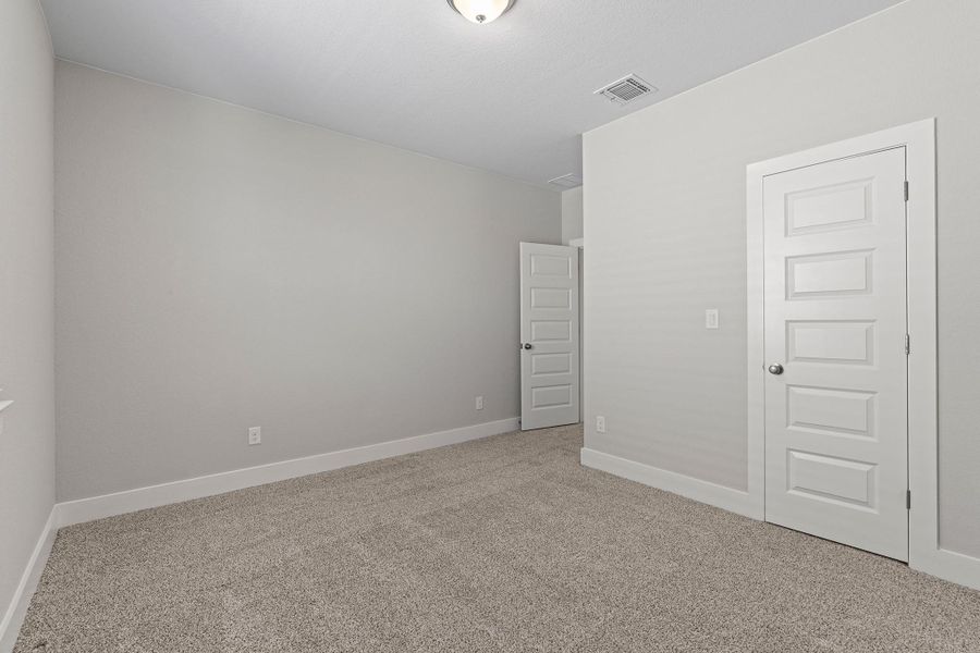 Unfurnished bedroom with light carpet and baseboards Unfurnished bedroom with light carpet and baseboards