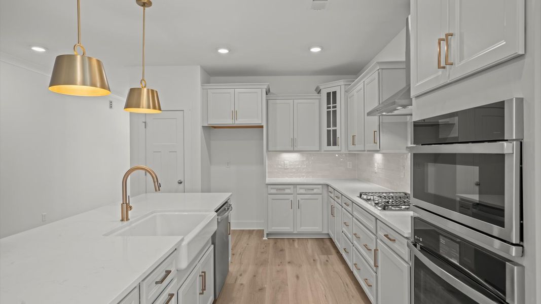 Highly skilled kitchen design includes an 8-foot island, quartz countertops, and stylish pendant fixtures