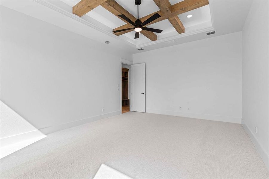 Carpeted spare room with beamed ceiling, coffered ceiling, and a ceiling fan