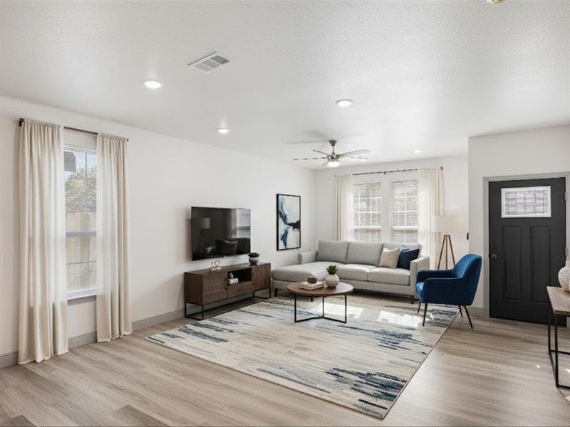 Living area with light wood finished floors, a ceiling fan, recessed lighting, and a textured ceiling