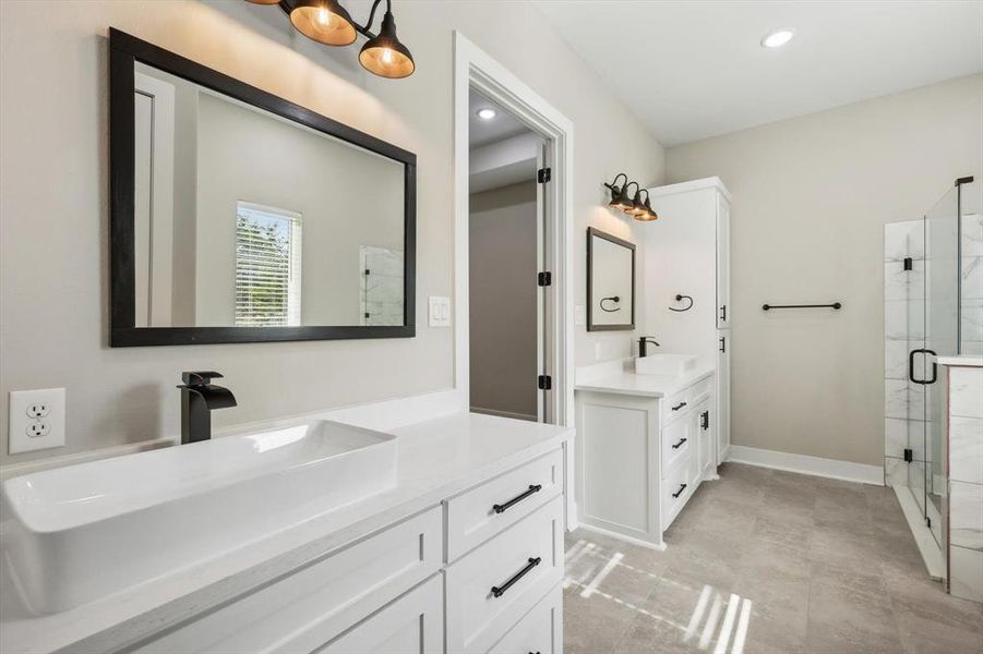 Bathroom featuring a shower with shower door and vanity