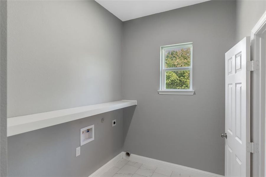 Washroom featuring hookup for an electric dryer, light marble finish flooring, and hookup for a washing machine Washroom featuring hookup for an electric dryer, light marble finish flooring, and hookup for a washing machine