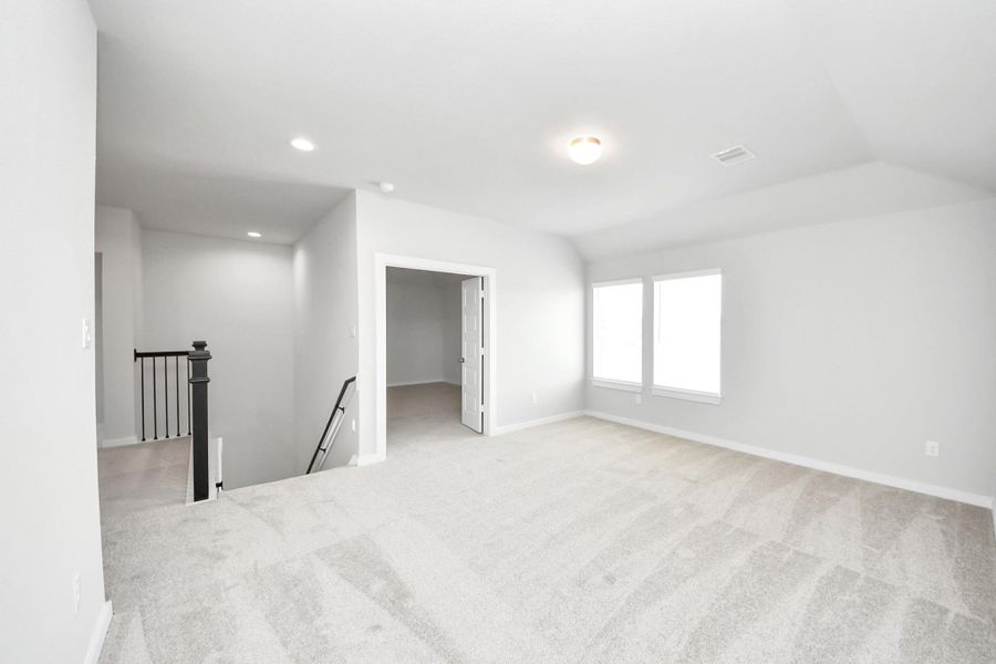 Come upstairs and relish a day of relaxation in this loft area! Ideal as an additional living space or game room, it boasts plush carpeting, high ceilings, custom paint, and windows that flood the area with abundant natural light. Come upstairs and relish a day of relaxation in this loft area! Ideal as an additional living space or game room, it boasts plush carpeting, high ceilings, custom paint, and windows that flood the area with abundant natural light.