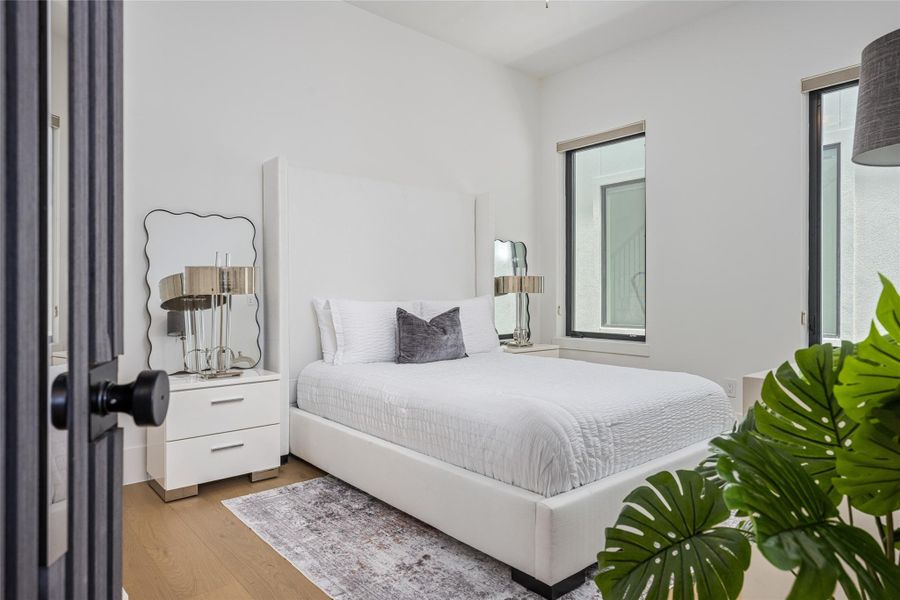A spacious downstairs secondary bedroom with a custom closet is paired with a luxe full bath, ideal for guests or multi-generational living A spacious downstairs secondary bedroom with a custom closet is paired with a luxe full bath, ideal for guests or multi-generational living