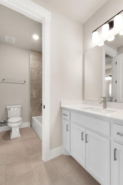 Full bath featuring vanity, light tile patterned floors, and bathtub / shower combination
