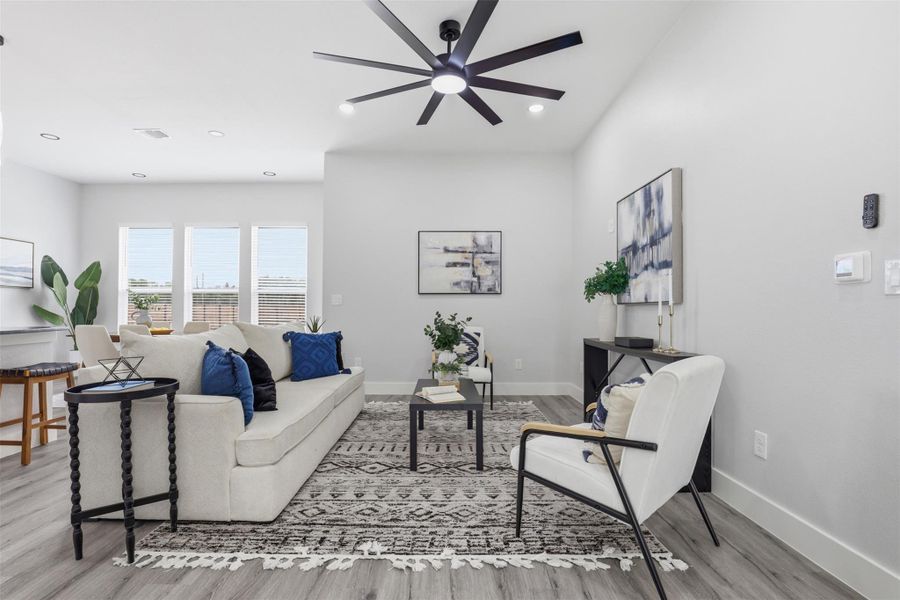 Open-concept living space featuring wood-finish flooring, recessed lighting, and a modern ceiling fan