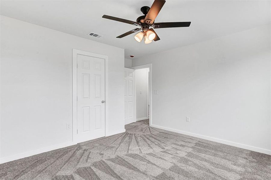 Unfurnished bedroom with carpet and a ceiling fan