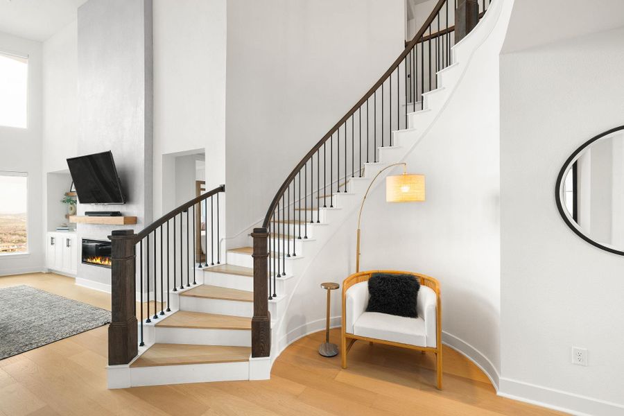 Curved staircase featuring dark wood newel posts and railings with black metal balusters Curved staircase featuring dark wood newel posts and railings with black metal balusters