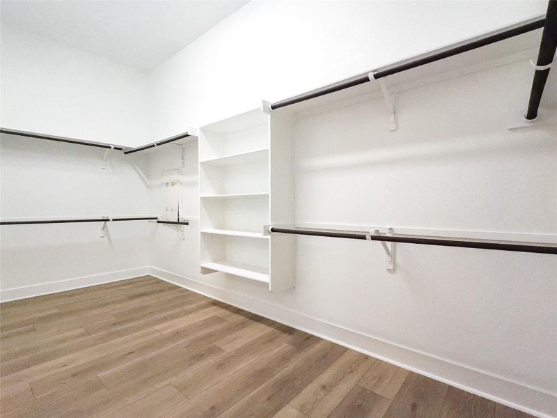 Walk in closet with light wood-style flooring Walk in closet with light wood-style flooring