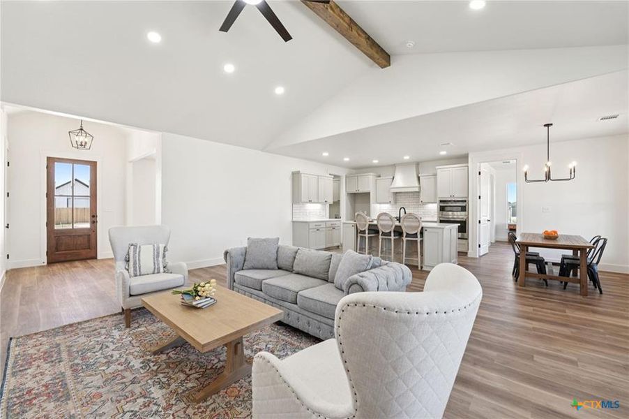 An open-concept living area with vaulted ceilings and a clear view to the kitchen and dining space. An open-concept living area with vaulted ceilings and a clear view to the kitchen and dining space.