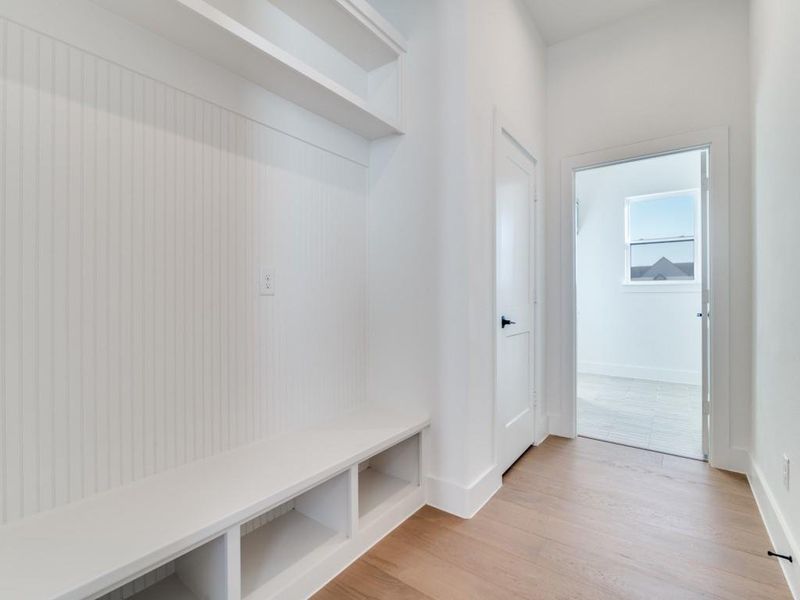 Mudroom featuring light wood-style flooring and baseboards