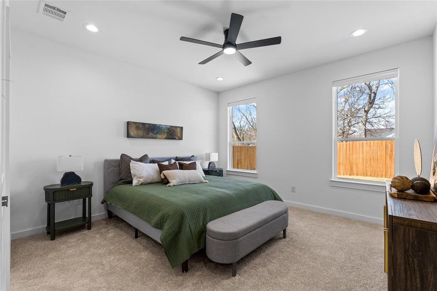 Bedroom featuring light carpet, ceiling fan, and recessed lighting Bedroom featuring light carpet, ceiling fan, and recessed lighting