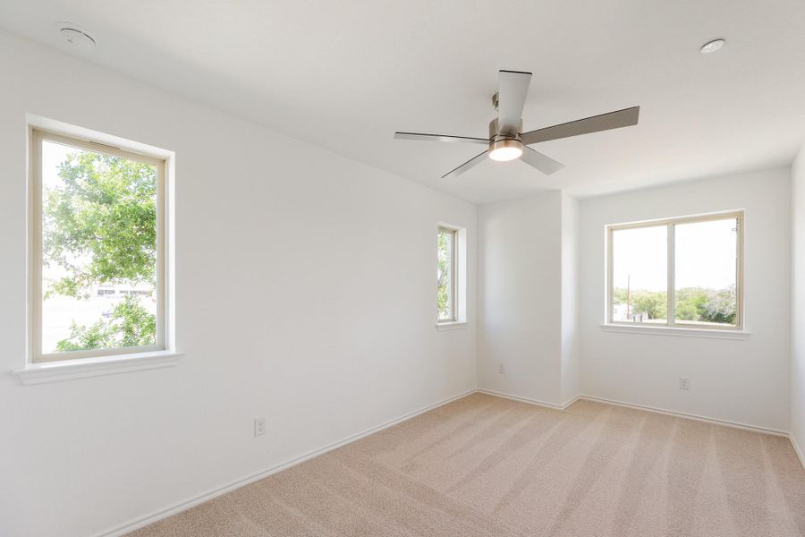 Spare room with light carpet and a ceiling fan