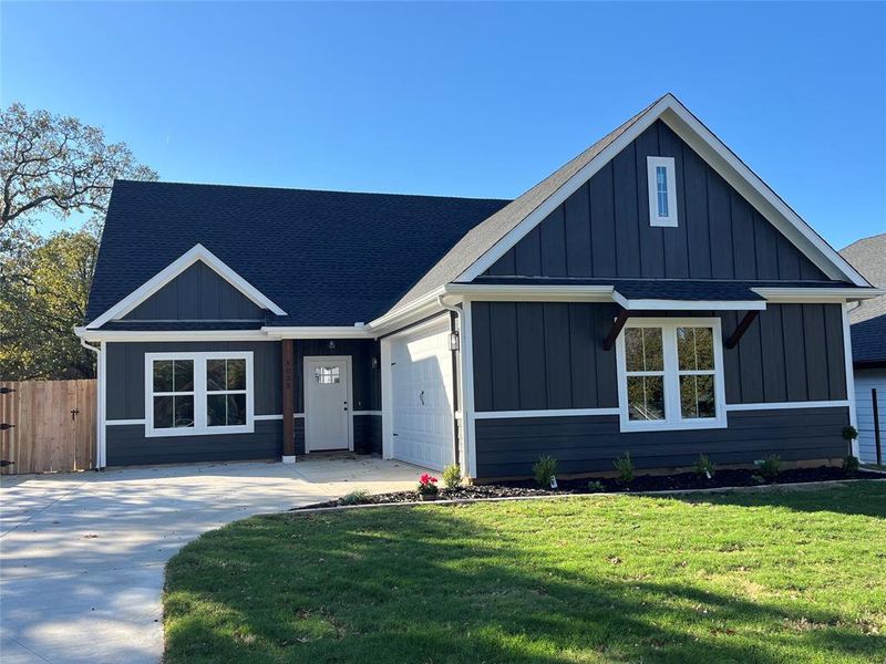 View of front of property with a front yard and a garage