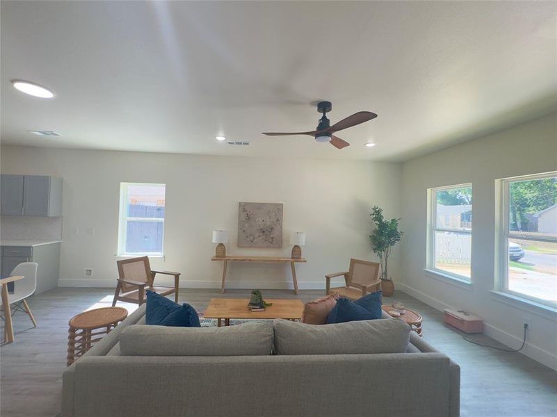 Living room with light wood-type flooring and ceiling fan