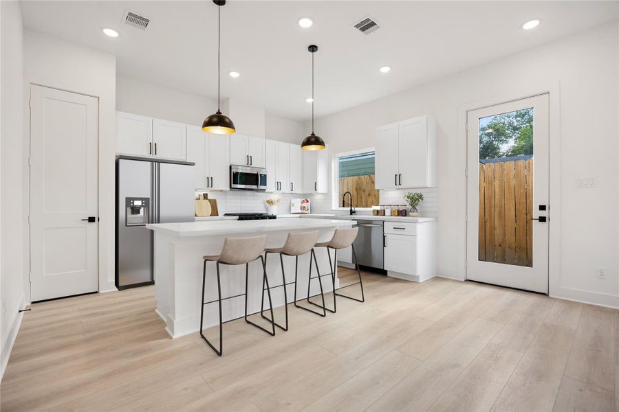The extended breakfast bar provides additional seating—perfect for a quick meal—while keeping you connected to conversations in both the kitchen and living room. *Virtually Staged