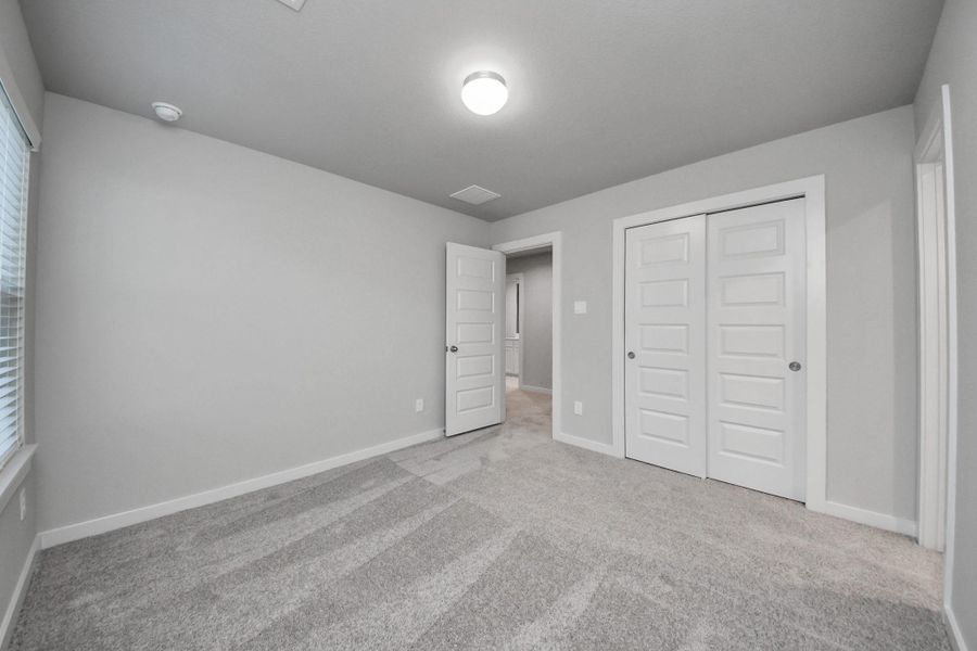 Generously sized secondary bedrooms featuring spacious closets, soft and inviting carpeting underfoot, large windows allowing plenty of natural light, and the added touch of privacy blinds for your personal retreat. v