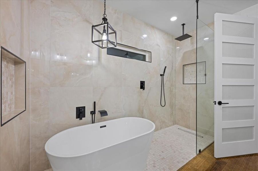 Your very own spa awaits with tile walls, a free-standing tub, and a marble finish shower
