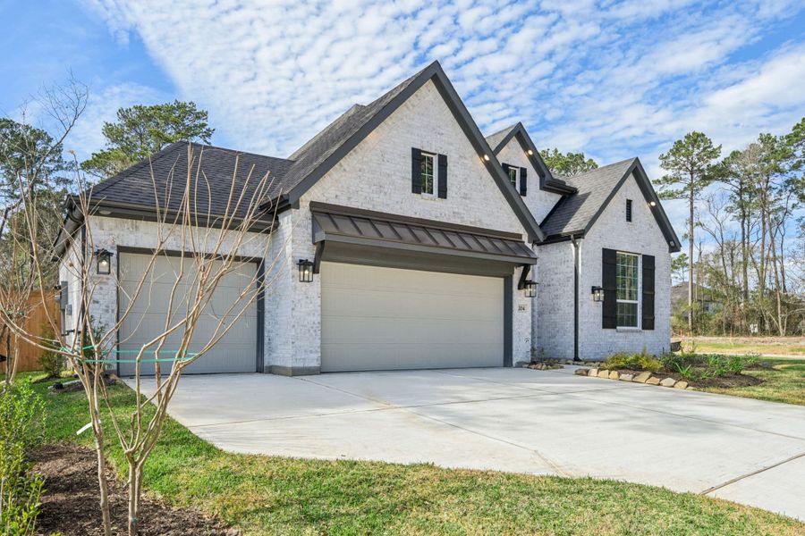 Front exterior of a new home in The Woodlands Hills, Willis, TX, highlighting curb appeal (Image 22).