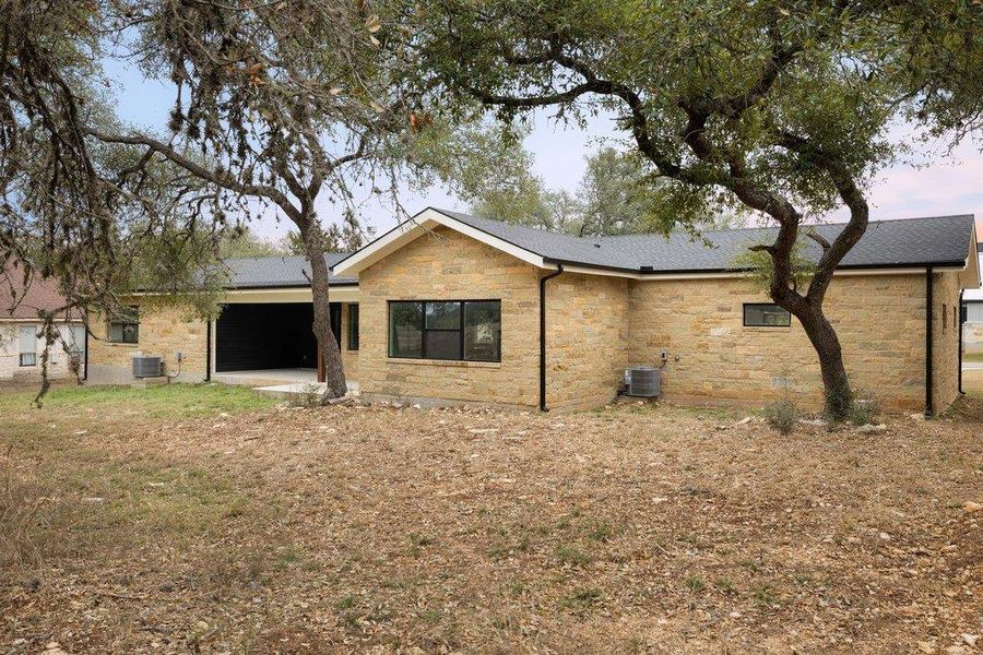 Back of house featuring a patio and stone siding