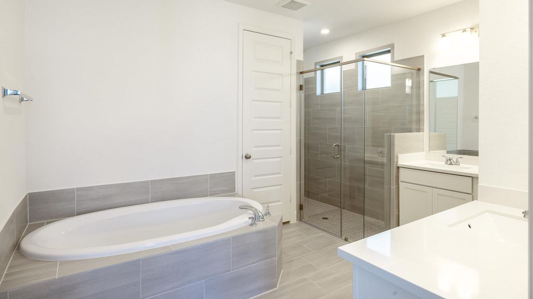 Bathroom with vanity, a bath, and a stall shower
