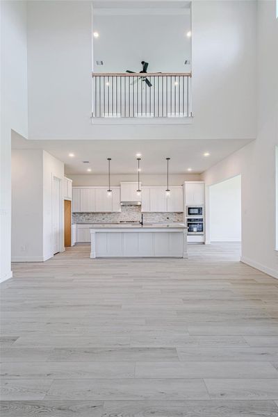 Spacious family room with high ceilings, ceiling fan, and versatile layout options