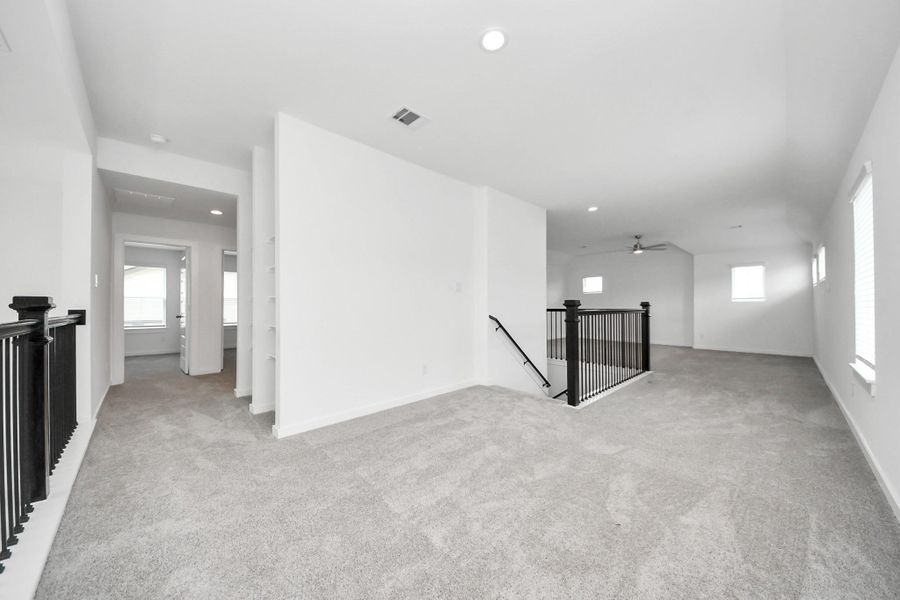 Discover a haven of leisure in this fantastic game room! Whether you're seeking a casual hangout or an adult gaming retreat, this space has it all. Enjoy the luxurious feel of plush carpet underfoot, the expansive ambiance of high ceilings, custom paint that adds a touch of personality, and windows that flood the room with refreshing natural light. Sample photo of completed home with similar floor plan. Actual colors and selections may vary. Discover a haven of leisure in this fantastic game room! Whether you're seeking a casual hangout or an adult gaming retreat, this space has it all. Enjoy the luxurious feel of plush carpet underfoot, the expansive ambiance of high ceilings, custom paint that adds a touch of personality, and windows that flood the room with refreshing natural light. Sample photo of completed home with similar floor plan. Actual colors and selections may vary.