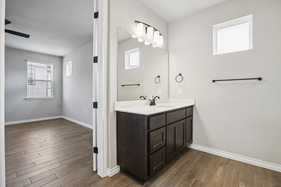 Bathroom featuring healthy amount of natural light, dark wood-type flooring, and vanity Bathroom featuring healthy amount of natural light, dark wood-type flooring, and vanity