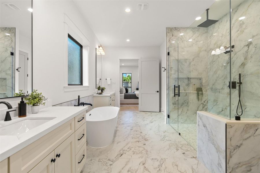A freestanding soaking tub, elegant finishes, and a stunning oversized shower transform your primary bath into a private spa retreat.