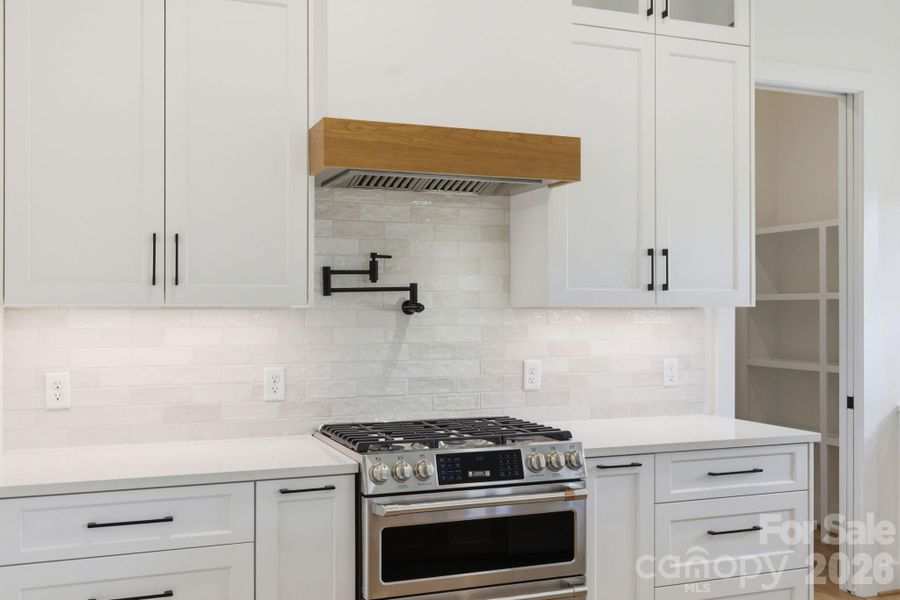 Chef's kitchen feat. double oven, gas range, & pot-filler