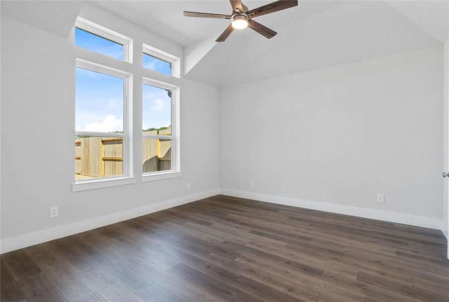 Retreat to this bright and airy primary bedroom, a serene sanctuary designed for ultimate relaxation and comfort. Vaulted ceilings, large windows, stylish laminate flooring, and modern ceiling fan give this room a peaceful space to come home to.