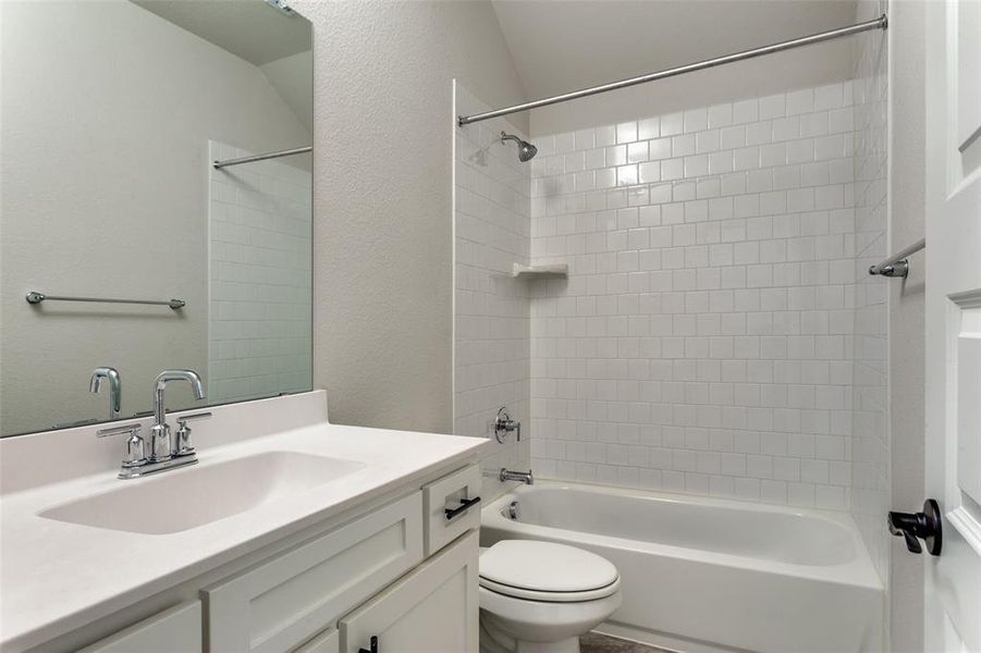 Full bathroom featuring shower combination, vanity, and a textured wall Full bathroom featuring shower combination, vanity, and a textured wall
