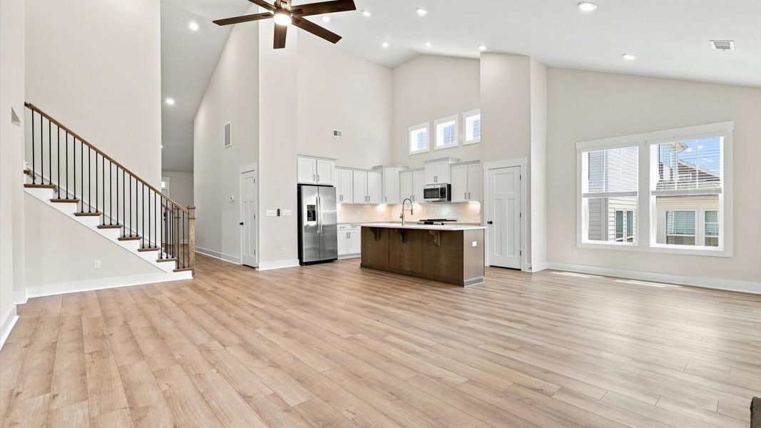 Spacious and stylish family room with two-story ceilings that create a bright and open atmosphere