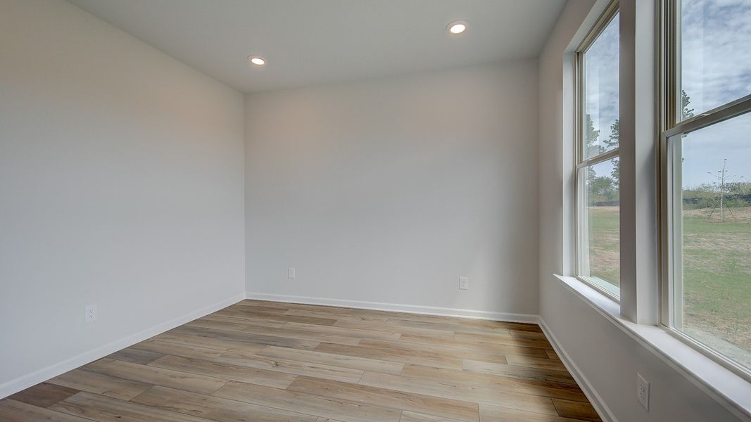 Stonefield secondary bedroom with carpet flooring and connected full bath at Brighton in Locust Grove, GA.