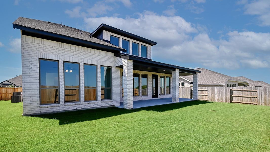 Rear view of property with brick siding and a patio