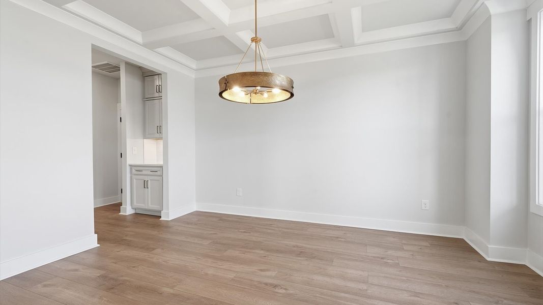 Eye-catching coffered ceiling adds charm to the formal dining space in this superior DRB Homes design