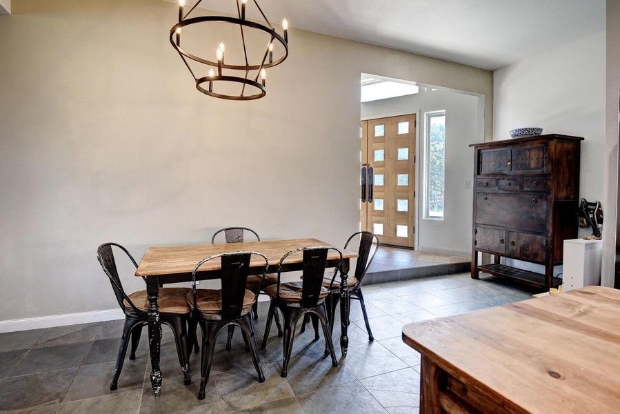 Dining area with light tile patterned floors and a chandelier Dining area with light tile patterned floors and a chandelier
