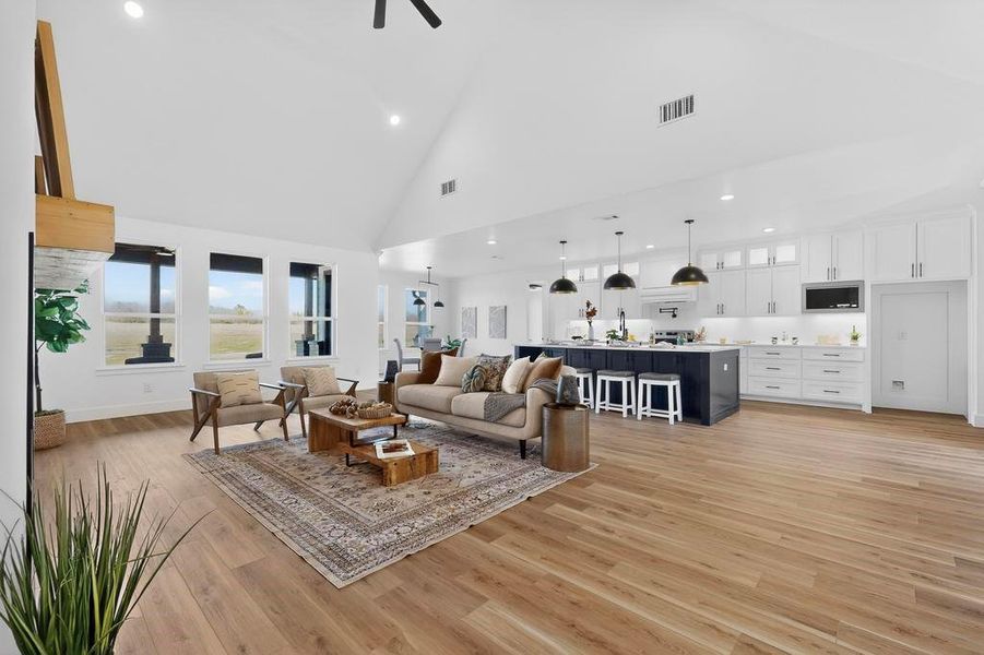 Living area with light wood finished floors, ceiling fan, lofted ceiling, and recessed lighting Living area with light wood finished floors, ceiling fan, lofted ceiling, and recessed lighting